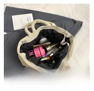 Top view of beige quilted tote bag interior showing large capacity and zip pocket