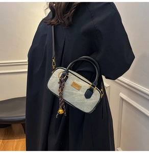 Detail of Boston-style mini bag featuring green marble texture and chic bell pendant