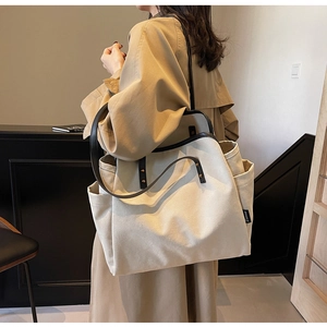 Detail of canvas tote bag showing side pocket, Ziyouse label and black leather strap