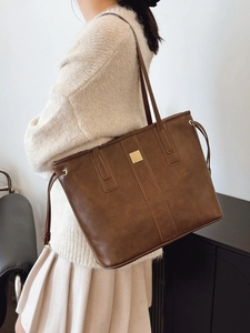 Retro dark brown tote bag with gold metal plaque and drawstring details for work