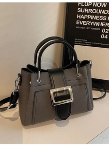 Minimalist grey twill bucket bag with black leather trim and silver metal buckle