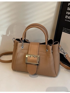 Minimalist khaki bucket bag with textured fabric, leather handle and metal buckle