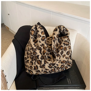 Gros plan du sac cabas en fausse fourrure léopard avec paillettes sur une chaise blanche