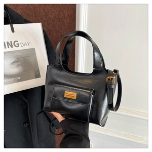 Détail d'un sac seau en similicuir noir avec boucles dorées et bandoulière réglable