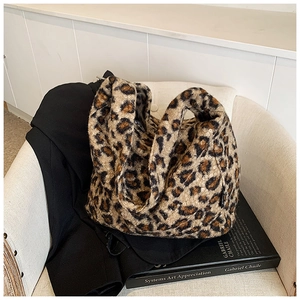 Gros plan du sac fourre-tout en fausse fourrure léopard sur un fauteuil blanc élégant