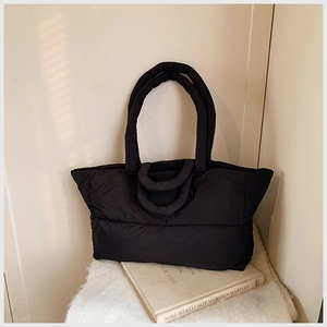 Close-up of black quilted puffer tote bag with waterproof nylon and dual handles