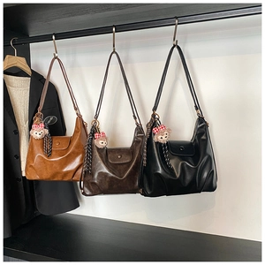 Three leather shoulder bags in brown and black colors with cute plush bear charms