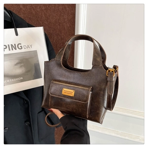 Détail du sac vintage en simili cuir marron foncé avec plaque dorée et poche aimantée