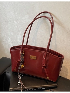 Vintage burgundy leather tote bag for women with gold logo and decorative strap