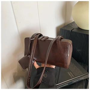 Detail of vintage dark brown faux leather shoulder bag with a mini pouch attachment
