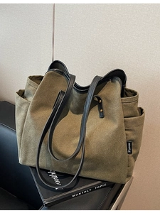 Army green canvas tote bag with black leather trim and side pocket for women