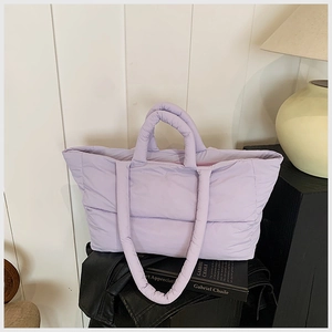 Macro shot of light purple quilted tote bag showing plush texture and shoulder straps