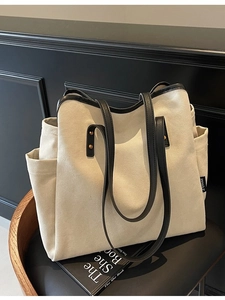 Large capacity canvas tote bag with black leather straps on a wooden chair
