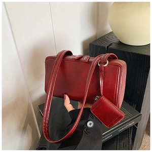 Detail view of burgundy retro pillow bag with matching mini coin purse attachment