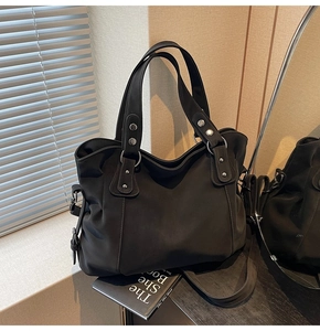 Détails du sac cabas rétro noir avec des rivets métalliques et une texture mate premium