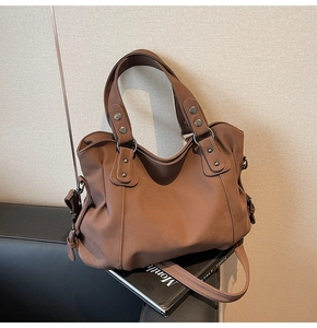 Détails d'un sac cabas marron vintage avec rivets métalliques et bandoulière amovible