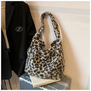 Sac fourre-tout en peluche léopard sur une valise argentée pour un look de voyage chic