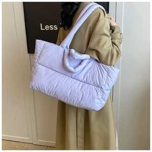 Close-up of light purple quilted puffer tote bag with dual strap design and soft glossy texture