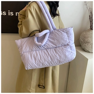 Lavender quilted down tote bag shown on model with spacious design for winter commute