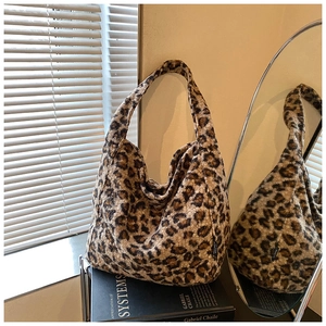 Détail d'un sac cabas en peluche léopard avec texture douce sur des livres