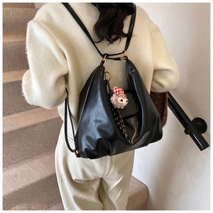 Minimalist black soft PU leather backpack worn by a model in a natural setting