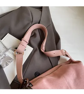 Detail of pink suede tote bag with smooth shoulder strap and sleek metal adjustment buckle