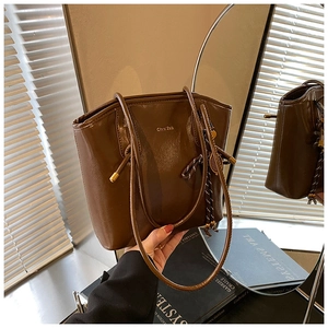 Détail du cabas en cuir marron foncé au fini ciré brillant et lettrage doré chic