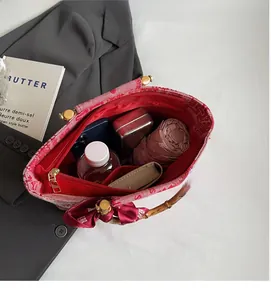 Interior view of red bridal tote bag showing large capacity with daily items and bamboo handles