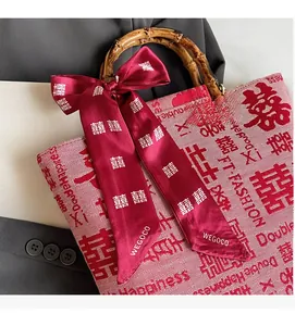 Detail of red wedding handbag with bamboo handle and double happiness print ribbon