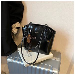 Sac cabas noir brillant avec logo doré et pendentif de raquette de tennis élégant
