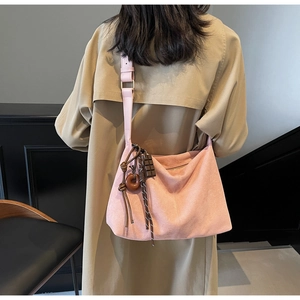 Pink suede tote bag with unique wood ring pendant and decorative woven knot charm
