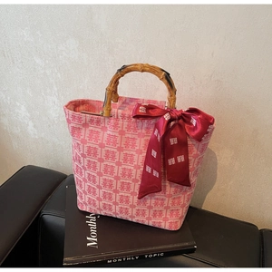 Detail of pink bridal tote bag with XI character jacquard and natural bamboo handles