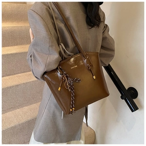 Vue détaillée du sac cabas marron brillant avec logo et charme en corde tissée