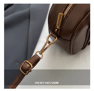 Close-up of bronze metal zipper with PANTOOR engraving and d-ring on brown leather bag