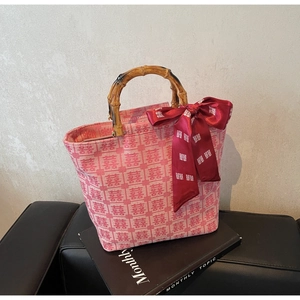 Detail of red wedding tote bag with double happiness patterns and bamboo handle