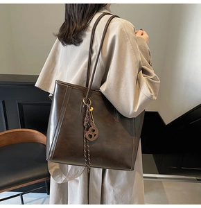 Detail of deep brown faux leather tote bag showing fine texture and decorative stitching