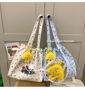 Close-up of a cartoon plush mushroom pendant on a colorful polka dot tote bag