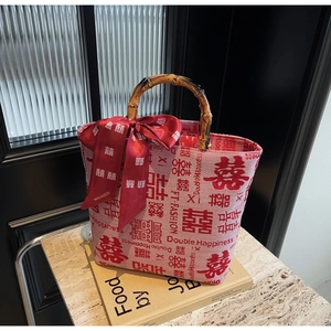 Detail of red wedding tote bag with bamboo handle, jacquard pattern and elegant silk bow