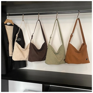 Detail view of large matte hobo shoulder bags in beige, brown, green and tan colors
