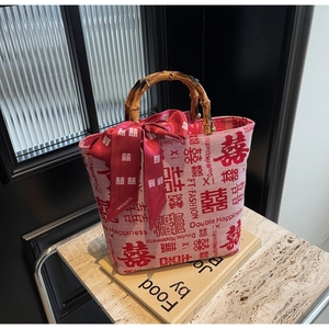 Detail of red wedding tote bag with double happiness jacquard and bamboo handle