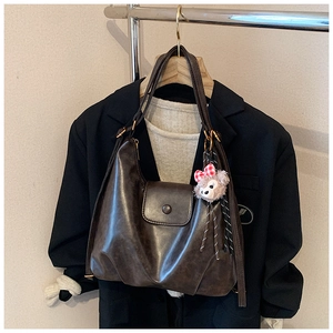 Detail of dark brown retro PU leather shoulder bag with ShellieMay plush charm on strap