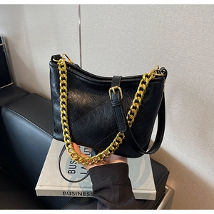 Detailansicht der schwarzen gesteppten Beuteltasche mit Goldkette und Lederstruktur