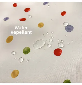 Close-up of waterproof tote bag fabric with colorful polka dots and water droplets