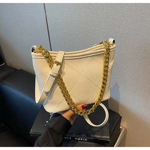 Detail der weißen Stepp-Beuteltasche mit Goldkette und strukturierter Lederoptik