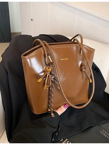 Sac seau chic en cuir marron brillant avec pendentif clé dorée et doubles anses