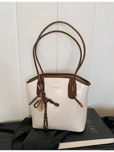 Sac seau rétro blanc avec bordure en cuir marron et pendentif raquette de tennis doré