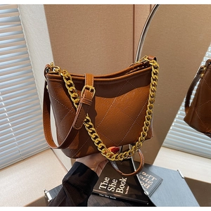 Detailansicht der dunkelbraunen Stepptasche mit goldener Kette und PU-Leder-Textur