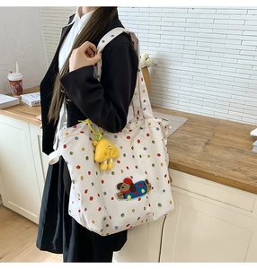 Detail of colorful polka dot canvas tote with cute dog patch and star plush charm