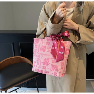 Pink canvas tote bag with bamboo handles and red silk bow for wedding use