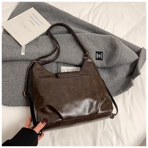 Detail view of coffee brown hobo bag with vintage texture and golden metal buckle